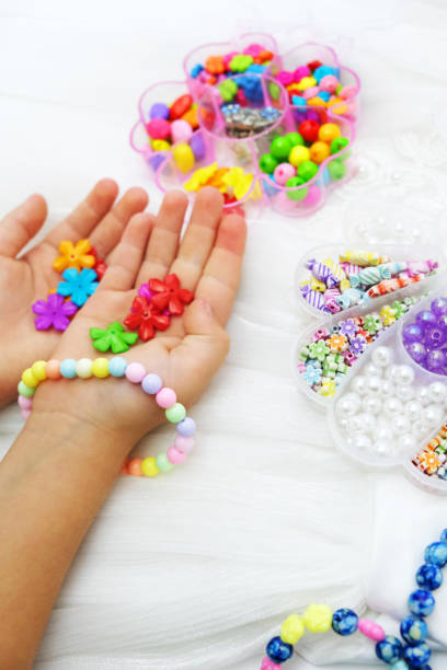 juego de cuentas multicolores para costura, niños haciendo joyas en casa. manualidades fáciles y creativas para niños y adolescentes - bead glass making jewelry fotografías e imágenes de stock