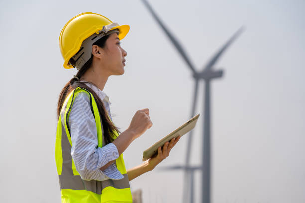 Female engineer planning on wind turbine maintenance work, nature renewable energy concept, wind power