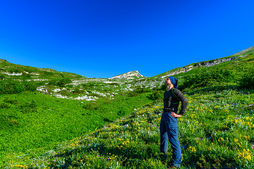 The man hiking in the tropical forest mountians. The alpine mountains and meadows.