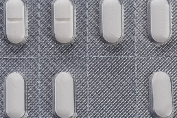 Whole blister pack with white oblong pills of the medication, fragment top view close-up