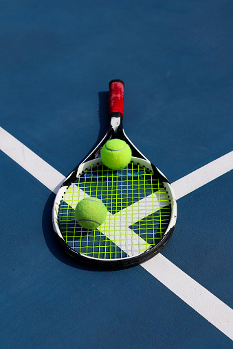 Close up view of tennis racket and tennis ball