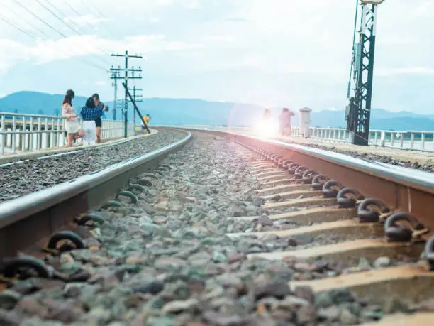 Photo of Railroad tracks run on a bridge over a river.