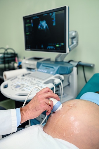 Doctor and a pregnant woman during ultrasound exam in the hospital