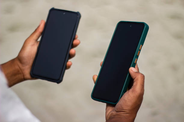 istock A boy is holding two mobile phones and the screen is black 1478964574