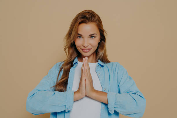 istock Young woman making namaste gesture isolated on beige background 1478972112
