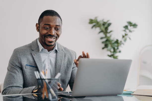 istock Young man has video conference on laptop. Freelancer is working online at workplace at home. 1478976035
