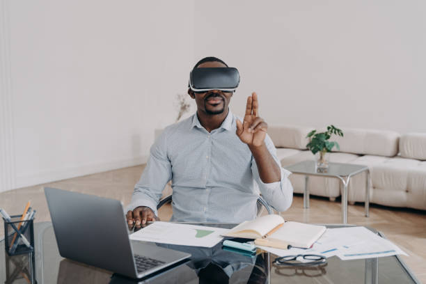 empresário afro-americano usando óculos de realidade virtual trabalhando no laptop. hightech, e-business - technology personal accessory hightech business - fotografias e filmes do acervo