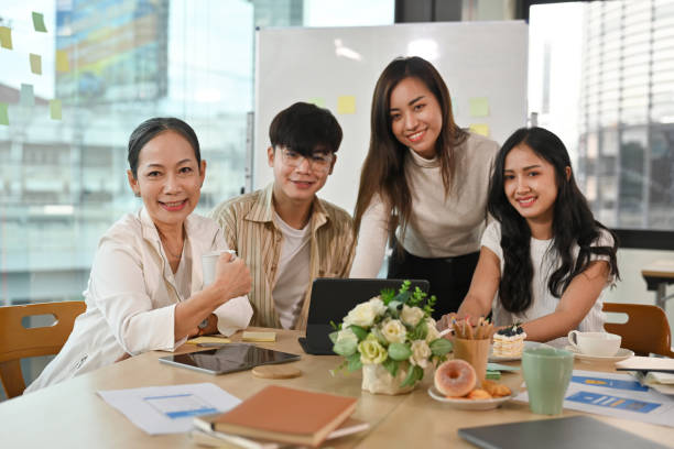 istock Diverse different aged business team sitting in the boardroom and looking at the camera. 1478978976