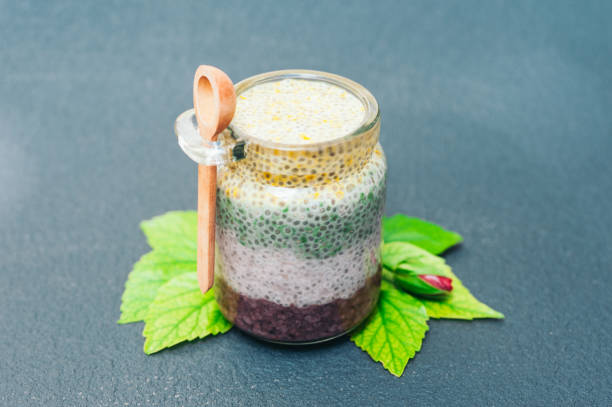 Healthy dessert and proper nutrition concept. Chia pudding in glass jar with wooden spoon. Chia seeds. Superfood. Selective focus. Milk dessert