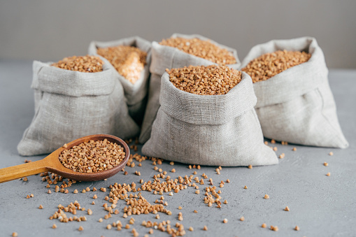 Green Soybeans Mung Beans dried legumes in a burlap sack bag and wooden serving scoop isolated on white background leaving copy space