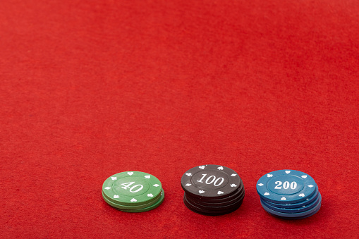 Gaming Chips on Red Velvet Playing Table - Casino and Gambling Concept for Poker and Table Games