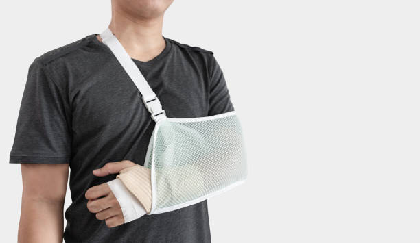 Young man with hand injured wearing splint, broken arm, isolated on white background Young man with hand injured wearing splint, broken arm, isolated on white backgrounds man with arm sling stock pictures, royalty-free photos & images