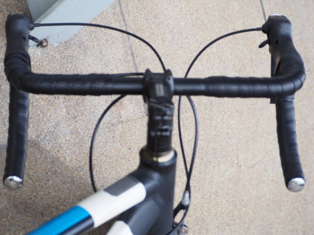 Black and blue gray bicycle handlebars and white lights
