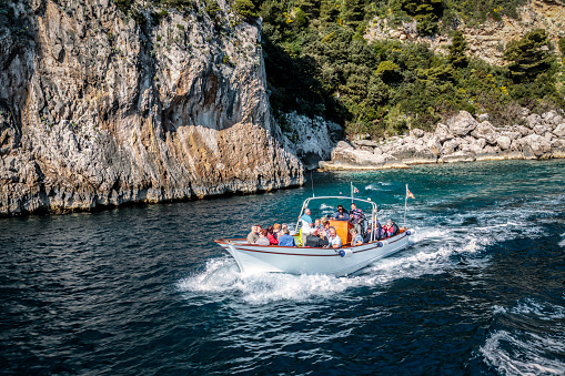 Island of Capri, Italy - March 21, 2017: View from the boat of a Boat with tourists along the cliffs and rocky  coast of Capri Island.