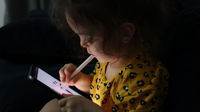 Little girl using digital tablet with digital pen
