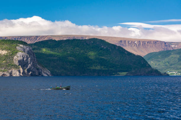Two men in a small fishing boat heading home, Gros Morne, Newfoundland
