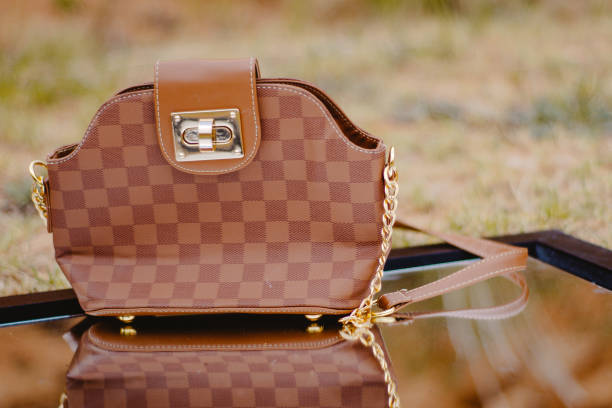 A selective focus shot of a brown shoulder bag on a mirror