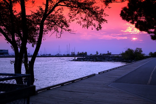 A bright sunset coloring the sky in red over the port of the River Credit in Ontario, Canada