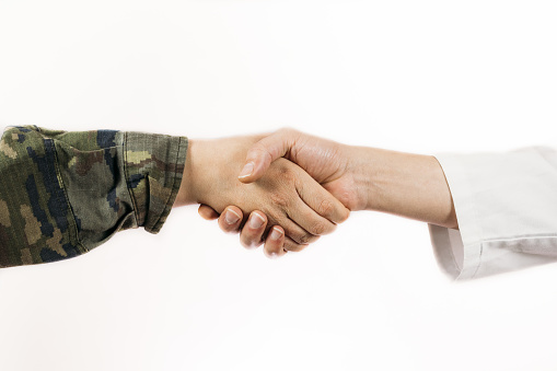 A closeup of a handshake of a soldier and a doctor