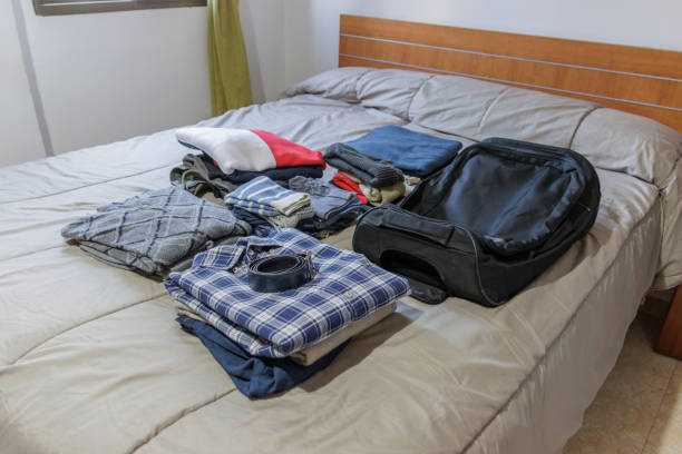 istock Clothes and suitcase on the bed prepared for a trip 1479033818