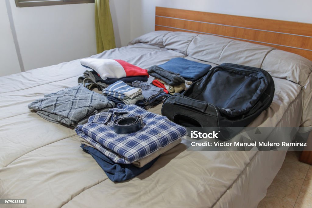 Clothes and suitcase on the bed prepared for a trip Clothes and suitcase on the bed at home prepared for a trip Adventure Stock Photo