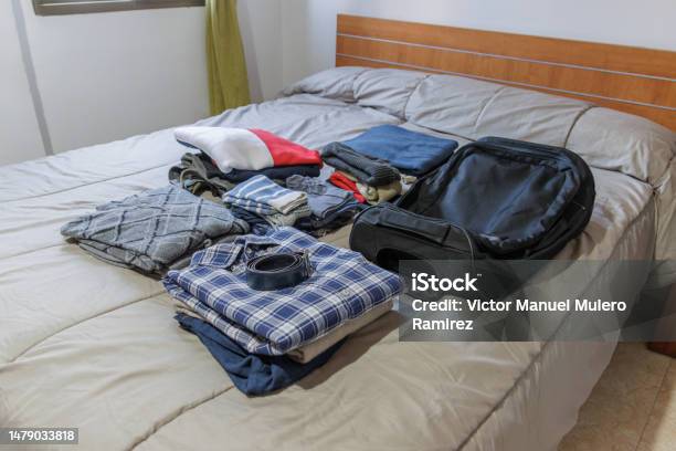 Clothes And Suitcase On The Bed Prepared For A Trip Stock Photo - Download Image Now