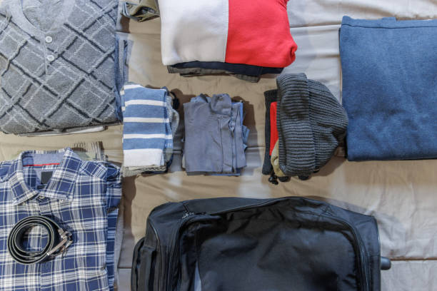 istock Clothes and suitcase on the bed prepared for a trip, top view 1479033824