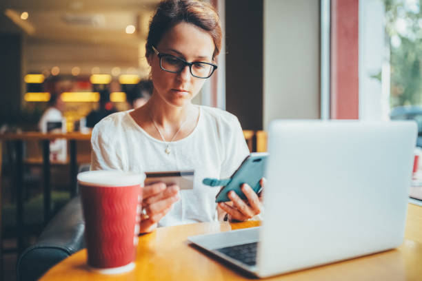 Woman in cafe making online payments stock photo