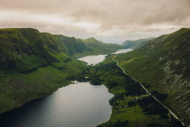 vista aérea da estrada ao longo da terra cênica dos lagos em colinas verdes na noruega - more objects - fotografias e filmes do acervo