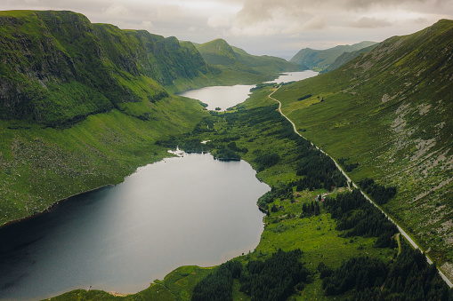 Drone high-angle photo of a country road by the three beautiful lakes surrounded by fresh summer mountain peaks on Stranda, Vestland county