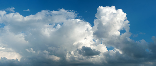 White cumulus clouds in a blue summer sky background