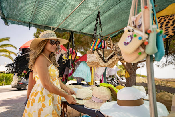 Woman buying sun hat on the beach European tourism in the Algarve in Portugal algarve holiday stock pictures, royalty-free photos & images