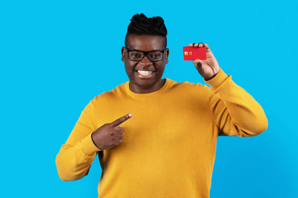 istock Cheerful Black Man Pointing At Credit Card In His Hand 1479050749