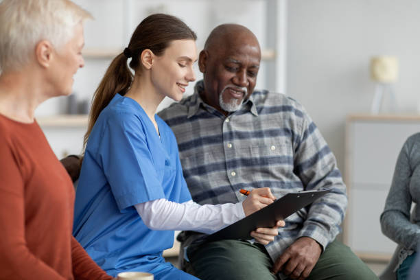 istock Supportive nursing home attendant helping senior black man filling papers 1479052724