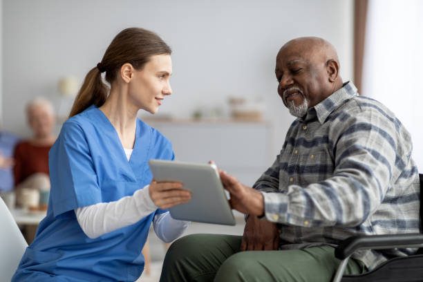 istock Friendly nurse helping black senior man using digital tablet 1479054615