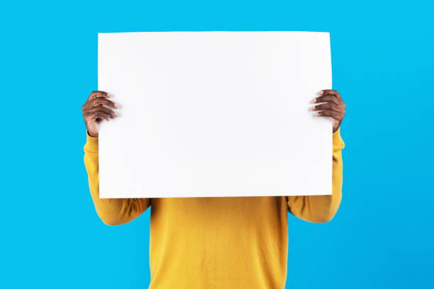 istock Young African American Man Hiding Face Behind Blank White Placard 1479054642