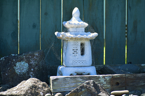 A closeup of an old Japanese stone lantern displayed outdoo