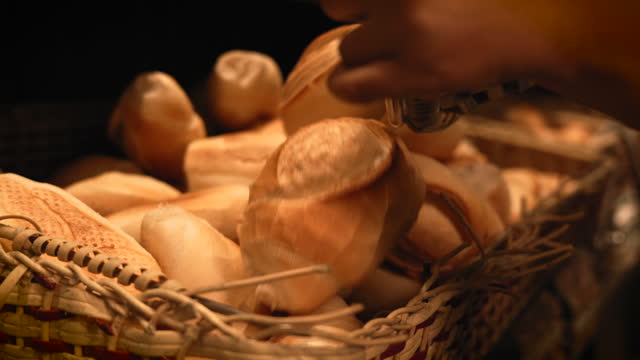 Man emptying fresh bread on a traditional bread basket