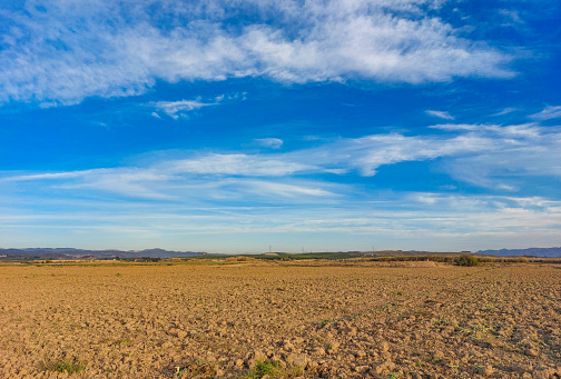 Farmland with the end of the horizon in clear blue sky with white clouds in the countryside of Vera (Almería).