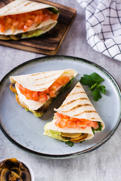 istock Grilled flatbread stuffed with avocado, mushrooms, tomatoes and parsley on a plate vertical view 1479066075