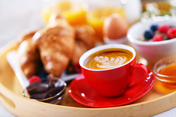 A tray with breakfast on a bed in a hotel room.