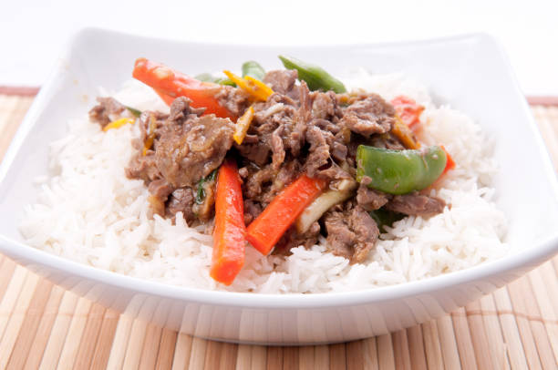 istock Closeup of stir-fried orange beef with rice made with flank steak 1479071393