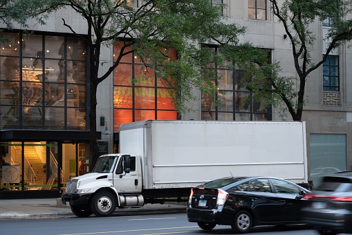 Chicago, United States – September 15, 2022: A white delivery truck parked on the side of a busy street in Chicago