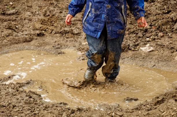 istock Boy joyfully standing in mud on rainy day, enjoying nature, Germany 1479077777