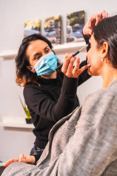 istock Makeup artist with a protective mask working in beauty salon 1479078174