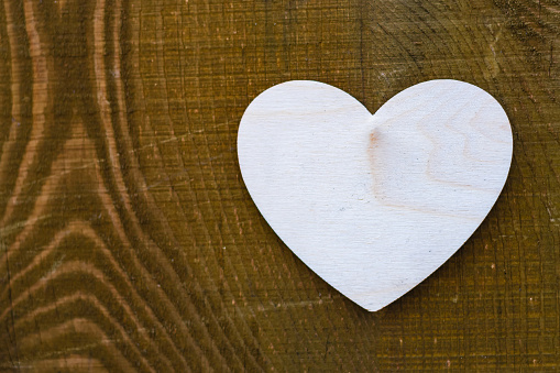 One wooden heart lies on a painted wooden surface, valentine's day