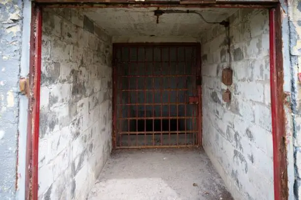 Close up shot of a jail cell door with a barred window
