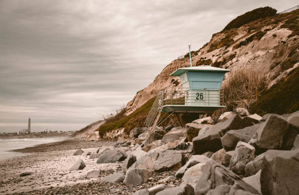istock Lifeguard tower on an empty beach full of big rocks under the cloudy sky 1479080605
