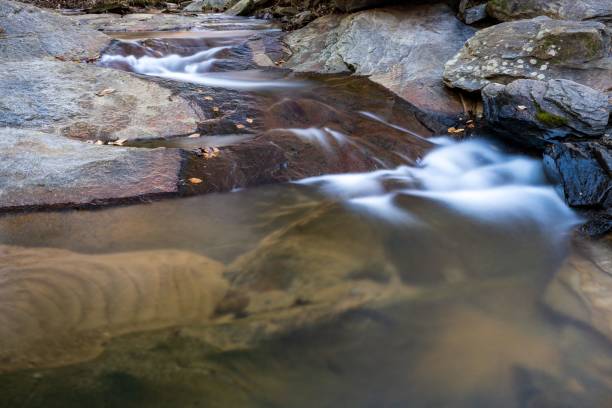 istock Crystal-clear stream of water cascades over a rocky ledge 1479083692
