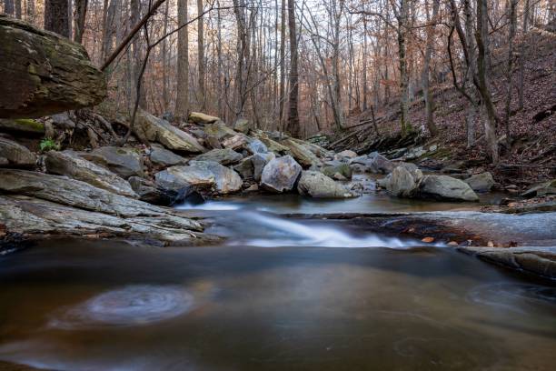 istock Tranquil stream meandering through a fall forest surrounded by jagged rocks 1479083717